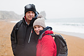 Portrait couple in warm clothing on winter beach