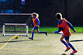Girls running, playing soccer