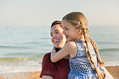 Mother holding daughter on beach