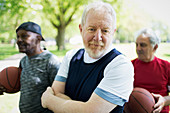 Active senior man playing basketball with friends