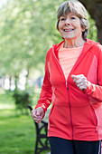 active senior woman running in park