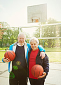 Active senior men friends playing basketball