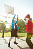 Active senior men playing basketball in park
