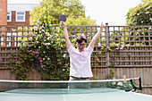 Exuberant man playing table tennis, celebrating