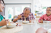 Family eating noodles with chopsticks