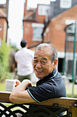 Portrait senior man drinking tea in yard