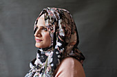 Serene, thoughtful woman wearing floral hijab