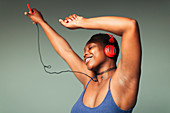 Carefree young woman with headphones dancing