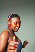 Carefree young woman with headphones dancing