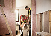 Construction workers mixing plaster in house