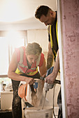Construction workers mixing plaster