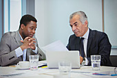 Businessmen discussing paperwork in meeting