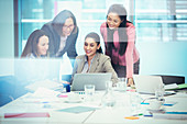 Businesswomen using laptop in meeting