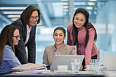 Smiling businesswomen using laptop in meeting