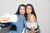 Teenage twin girls taking selfie
