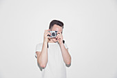 Teenage boy using retro camera