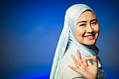 Young woman in hijab gesturing OK