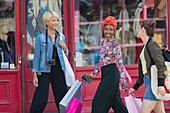 Young women friends shopping, walking