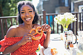 Young woman with pretzel enjoying breakfast