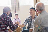 Men shaking hands in group therapy