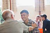 Smiling men talking in community centre