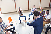 Man talking to men in group therapy