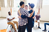 Men hugging in group therapy