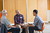 Men talking and listening in group therapy