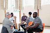 Men talking in group therapy