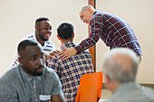 Men talking, comforting in group therapy