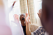 Smiling man with arms raised praying