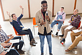 Man with microphone talking, leading group therapy