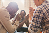 Men praying with rosary in prayer group