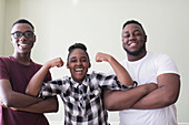 Portrait teenage brothers and sister flexing muscles