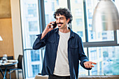 Man talking on smart phone in apartment