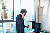 Man talking on smart phone in urban apartment