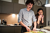 Couple cutting vegetables, preparing dinner