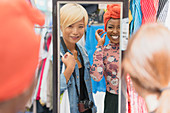 Young friends shopping at mirror