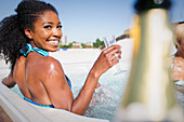 Woman drinking champagne in hot tub