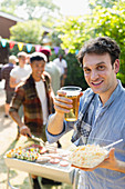 Portrait man drinking beer and barbecuing