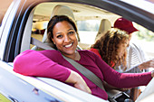 Portrait woman in car with family on road trip