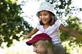 Happy, carefree girl on father's shoulders