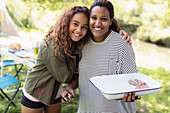 Portrait affectionate mother and daughter barbecuing