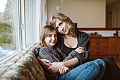 Portrait affectionate mother and daughter cuddling