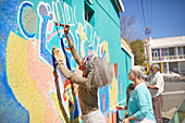 Senior community volunteers painting vibrant mural