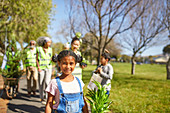 Portrait girl volunteering, planting trees in park