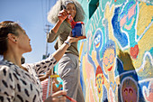 Female volunteers painting vibrant community mural