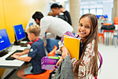 Portrait student carrying books in library