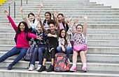 Portrait enthusiastic students waving on steps