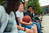 Tween boys with basketball in schoolyard